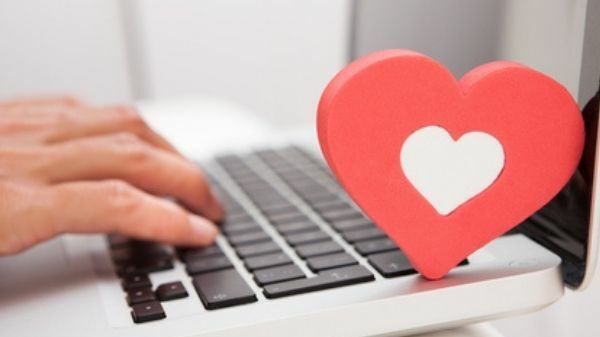 Hand auf einem Laptop mit einem Herz