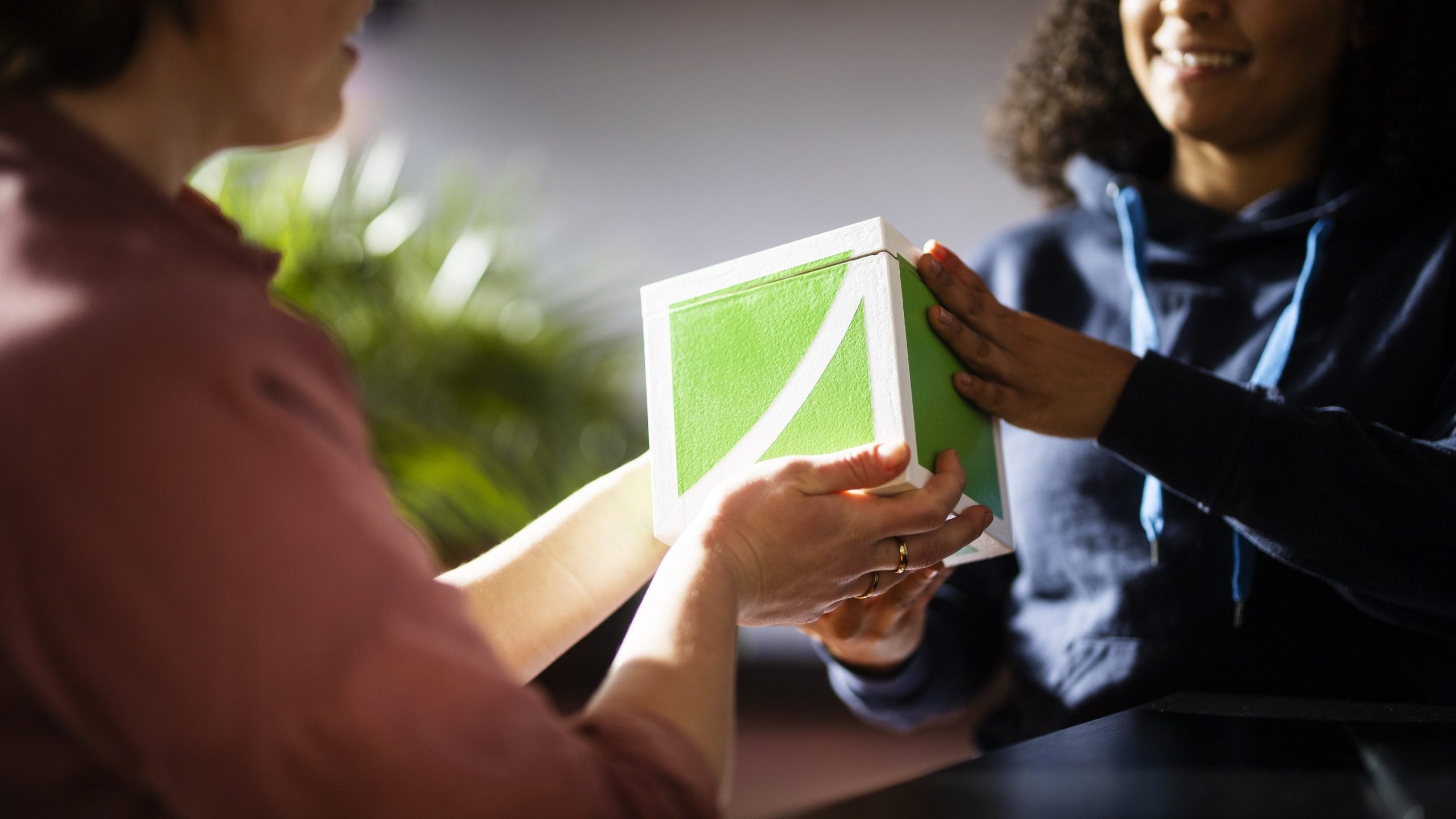 Zwei Personen halten einen FundraisingBox-Würfel aus Holz in der Hand