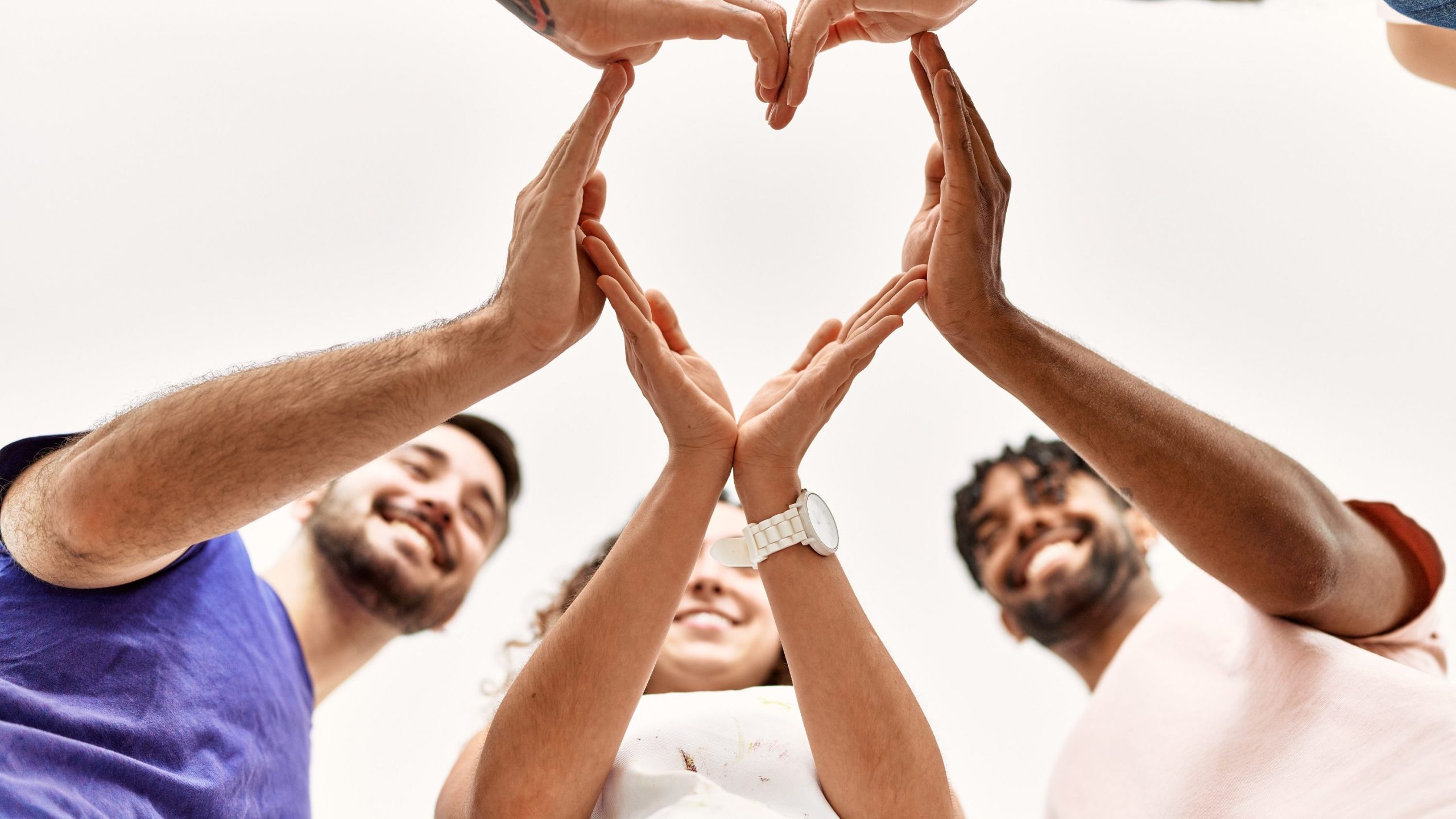 Eine Gruppe von Menschen formt gemeinsam ein Herz mit den Händen