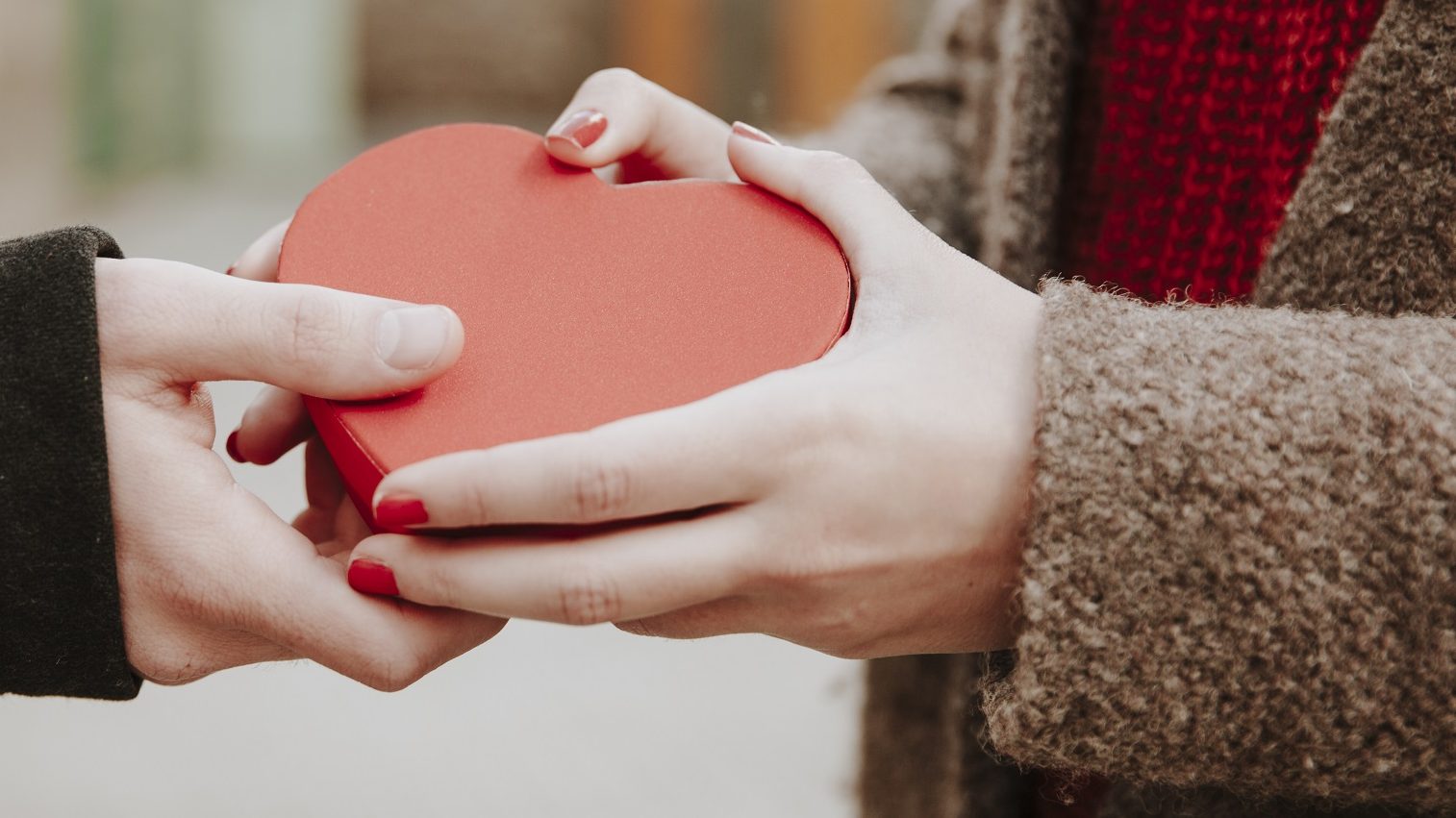 Zwei Menschen halten eine Herz-Schachtel in der Hand