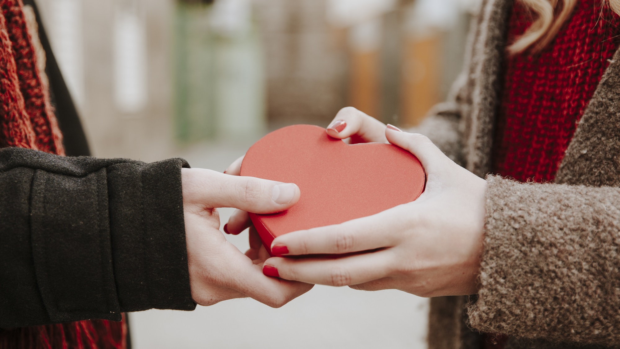 Zwei Menschen halten eine Herz-Schachtel in der Hand