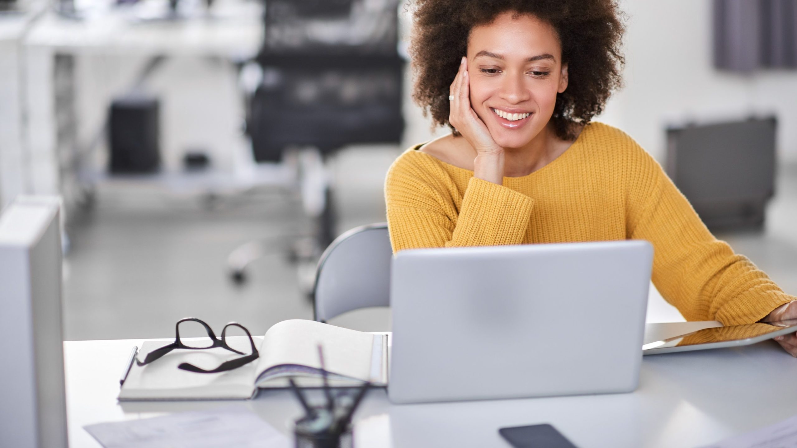 Frau sitzt lächelnd am Laptop