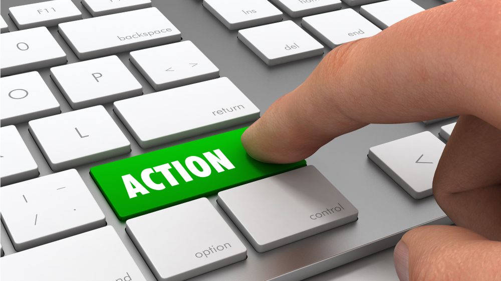 Tastatur, ein Finger klickt auf einen Button der "Action" zeigt